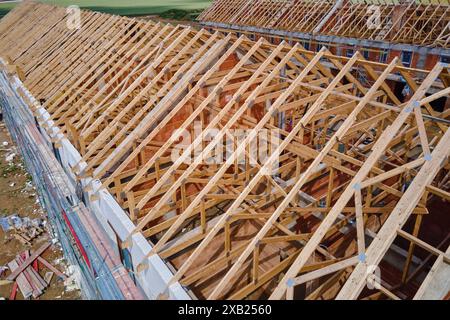 New house under construction, wooden truss system forming roof. Process of building project. Stock Photo