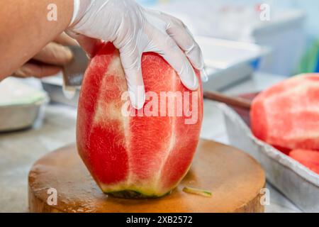 Cropped hand peeled watermelon on cutting board Stock Photo