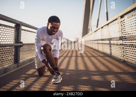 Young african-american man is injured while jogging. He twisted his ankle. Stock Photo