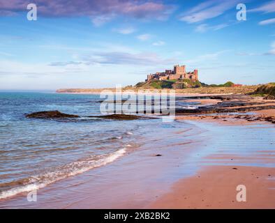 Looking along the edge of the ocean towards Bamburgh Castle, Northumberland, UK Stock Photo