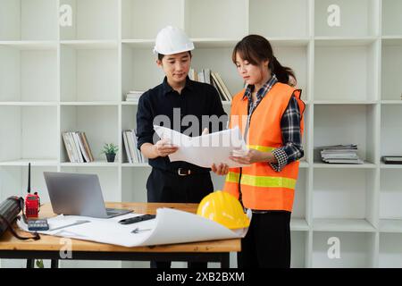 Engineers collaboration on Construction Project in Modern Office with Blueprints and Safety Gear Stock Photo