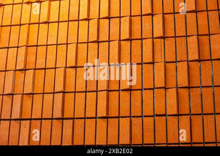 The background of the wall is made of vertical rows of brickwork of a brown yellow burnt color with dark seams Stock Photo