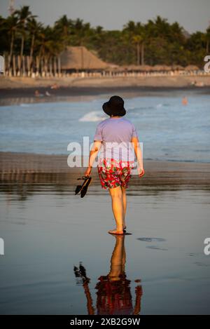 Woman walking at sunset on the Beach in El Tunco, El Salvador Stock Photo
