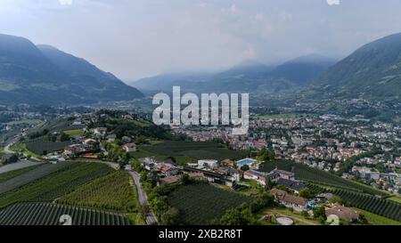 Dorf Tirol, Südtirol, Italien 07. Juni 2024: Hier der Blick, Drohne auf die Ortschaft Dorf Tirol, Tirolo oberhalb von Meran , Meraner Land, Burggrafenamt, wandern, spazieren, Tourismus, Hotspot, Urlaubsdomizil, Hier der Segenbühel, mit Meran und dem Etschtal *** Dorf Tirol, South Tyrol, Italy 07 June 2024 Here the view, drone on the village Dorf Tirol, Tirolo above Meran, Meraner Land, Burggrafenamt, hiking, walking, tourism, hotspot, vacation domicile, here the Segenbühel, with Meran and the Etsch Valley Stock Photo