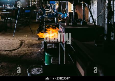 A moody shot inside a traditional blacksmith workshop, showcasing a blazing forge and an array of metalworking tools. Stock Photo