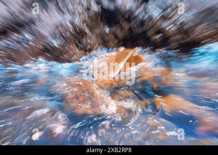 A dynamic image showing abstract, swirling colors blending seamlessly within a body of seawater, enhanced by motion blur and vivid hues capturing the Stock Photo