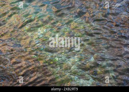 Close-up image capturing the shimmering reflections and subtle ripples of the sea, enhanced by light patterns on the water's surface Stock Photo