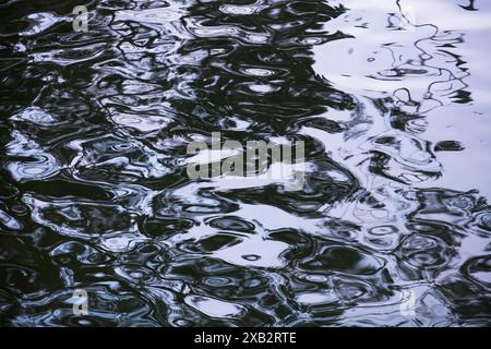This image captures abstract patterns and reflections on the surface of the sea, rendered in monochrome tones to emphasize texture and movement Stock Photo