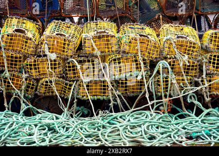 Piles of yellow lobster pots and green ropes used in commercial fishing at the port of Viavelez, Asturias. Stock Photo