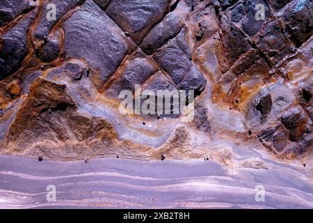 Abstract textures and patterns in multi-colored rock surfaces, ideal for fine art and geological themes. Stock Photo