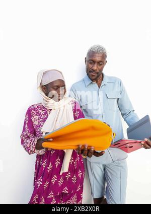 Two people engaged in a business meeting, sharing documents in bright folders, representing a productive summer breakfast meeting with a nature-inspir Stock Photo