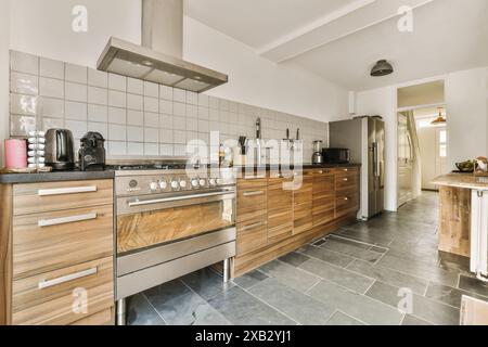 A contemporary kitchen with wooden cabinets, stainless steel appliances, and tiled backsplash located in Roggebotstraat, Amsterdam Stock Photo