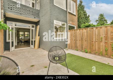 Cozy patio leading to a modern home's open-plan interior, with chic design elements and green outdoor touches. Stock Photo