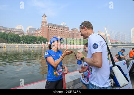 (240610) -- TIANJIN, June 10, 2024 (Xinhua) -- Laura Mora (L), a Spanish engineer from Airbus China, talks with her friend during the 2024 Haihe Dragon Boat Race in north China's Tianjin on June 10, 2024. On the day of the Dragon Boat Festival, Laura Mora finished her dragon boat race in the 2024 Haihe Dragon Boat Race for the first time. Born in coastal city Cadiz, the spanish engineer is familiar with many water sports, but the dragon boat race with a long history stays fresh to her. 'Participating in Dragon Boat races is not just for Dragon Boat Festival entertainment to me, but also a good Stock Photo