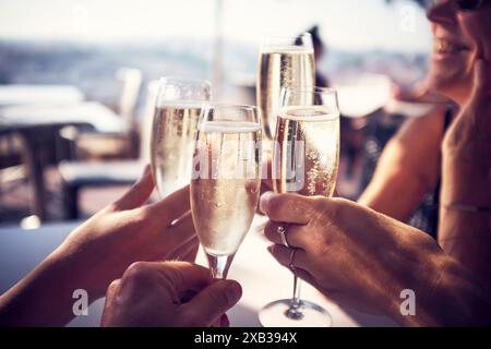 Hands of male and female friends toasting champagne flutes in restaurant Stock Photo