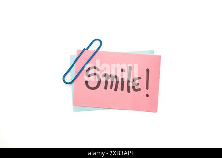 Smile word on a pink sticky paper on a white background Stock Photo
