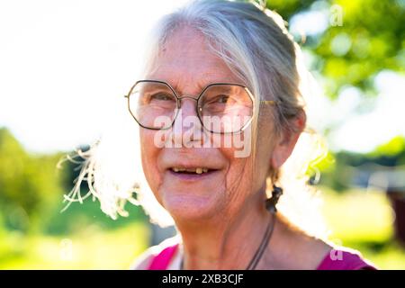 Close-up of cheerful senior woman in eyeglasses on sunny day Stock Photo