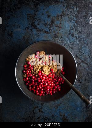 Cherries with brown sugar and spoon in bowl Stock Photo
