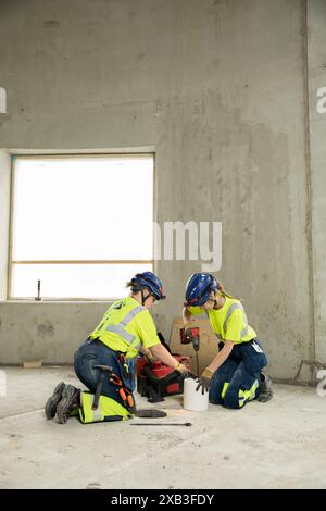 Full length of female engineers in protective workwear working together at construction site Stock Photo