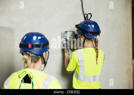 Female engineers working on electrical equipment at construction site Stock Photo