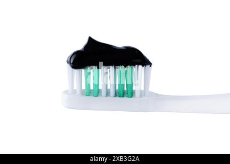 Charcoal toothpaste on toothbrush isolated on white background. Swatch of black charcoal whitening toothpaste on brush for design. Stock Photo