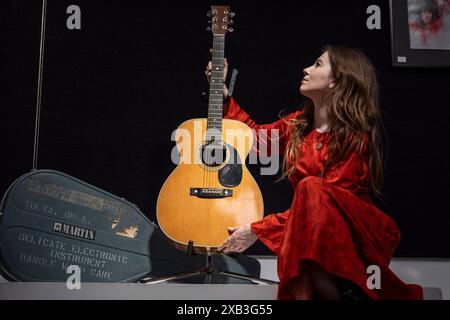 London, UK.  10 June 2024. A staff member presents ‘The Martin 000-28 Flat-Top Acoustic Guitar’, 1974, used by Eric Clapton to compose ‘Wonderful Tonight’, his love song to Pattie Boyd (Est. £300,000 - £400,000) at a preview of Bonhams’ Rock, Pop & Film sale.  Lots will be auctioned on 12 June at Bonham’s Knightsbridge galleries.  Credit: Stephen Chung / Alamy Live News Stock Photo