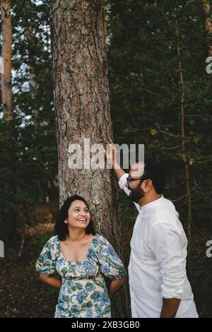 Cheerful couple standing near tree in park Stock Photo