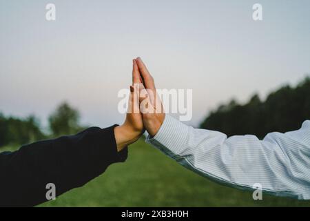 Hands of young couple touching each other against clear sky Stock Photo