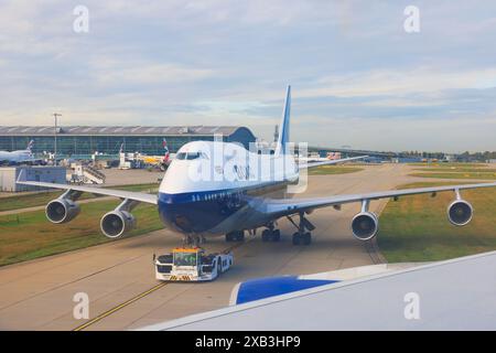 British Airways Boeing 747-400, G-BYGC, painted in retro BOAC colours to mark the centenary of BA. Tugged by Douglas tractor unit. London Heathrow, 20 Stock Photo