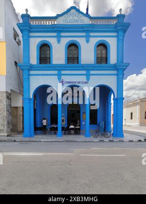 374 People at wait in the striking outdoor waiting room under the entrance arcade of the local Post and Telegraph Office. Bayamo-Cuba. Stock Photo