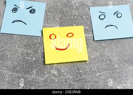 Emotional smiley faces on sticky notes on grey background, closeup Stock Photo