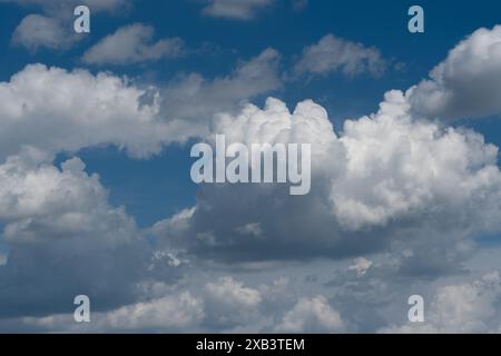 Cumulus clouds are illuminated by the bright sun on a blue sky background Stock Photo