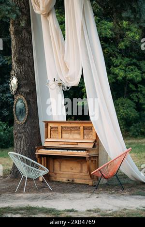 piano and chair with romantic decor in summer in garden. Decor for a wedding or a romantic dinner Stock Photo