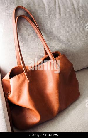 Brown leather bag standing on the sofa Stock Photo