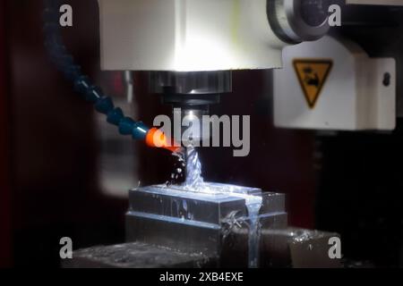 Closeup of metal milling process using CNC machine and cutting fluid. Selective focus. Stock Photo