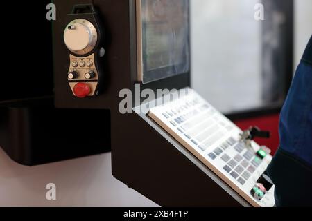 CNC control panel of industrial machining center with handheld remote controller close up. Selective focus. Stock Photo