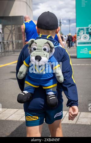 The 2024 rugby league Betfred Challenge Cup Final at Wembley between Warrington and Wigan. Young boy wearing a 'Wolfie' backpack outside the Stadium Stock Photo