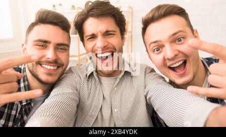 Three happy young men smiling at the camera Stock Photo