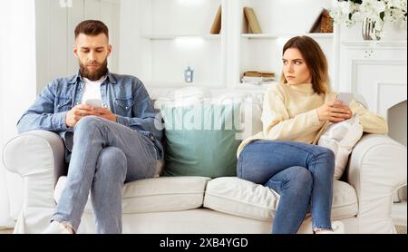 Couple Crisis. Man Using Phone, Not Paying Attention To Wife Stock Photo
