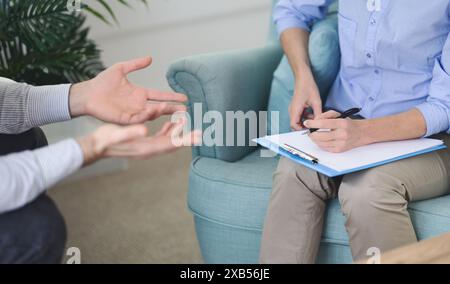 Therapist Taking Notes During Counseling Session in Modern Office, Afternoon Stock Photo