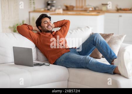 Relaxed Man Resting on a White Couch Stock Photo