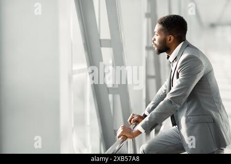 Feeling Relaxed. Confident Businessman Looking Through Window Stock Photo
