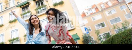 Two Happy Multiethnic Girlfriends Laughing, Having Fun While Posing Outdoors Stock Photo