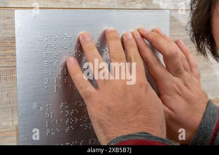 Close up of male hand reading braille text Stock Photo
