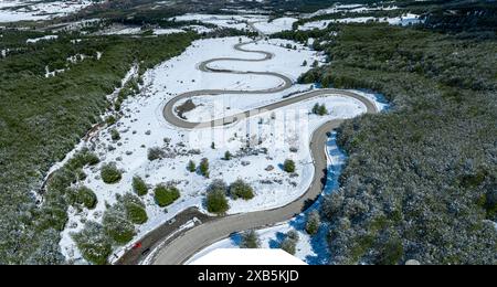 Mountain pass down to village Villa Cerro Castillo, aerial view of serpentines in snow-covered landscape, Patagonia, Chile Stock Photo