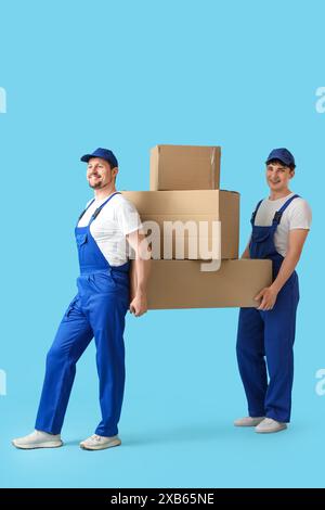 Loaders carrying cardboard boxes on white background Stock Photo - Alamy