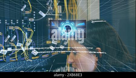 Caucasian woman in her 40s working with network cables and futuristic digital interface Stock Photo