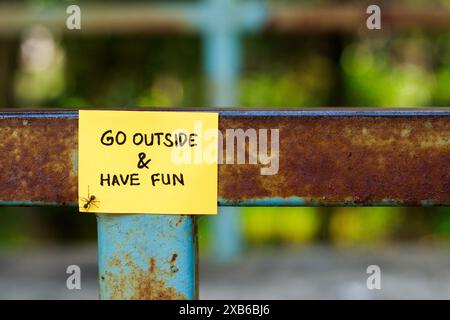 invitation to go outside, sticky notes attached to park posts Stock Photo