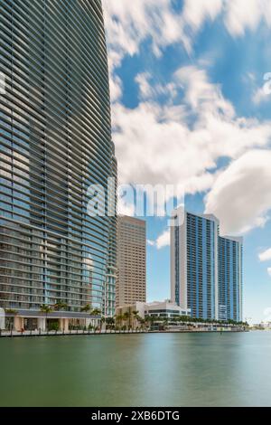 Highrise towers on the Miami River. Florida USA 2024. Long exposure with motion blur in water and clouds Stock Photo