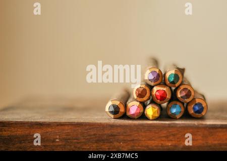 Vibrant colored pencils arranged on a rustic wooden surface in close-up view Stock Photo